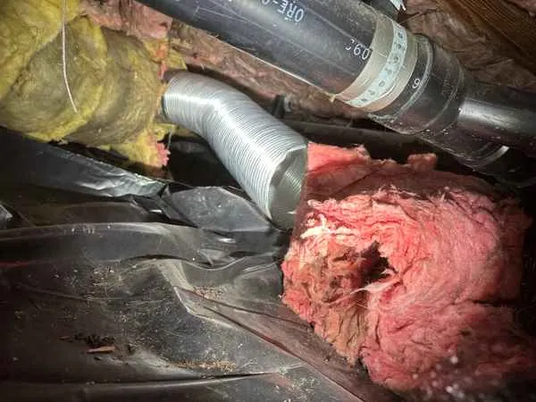 Flexible heating duct pulled loose from its connection in a crawlspace