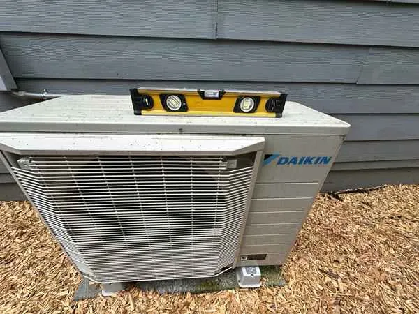 Level resting on an outdoor condenser unit that sits tilted on its pad