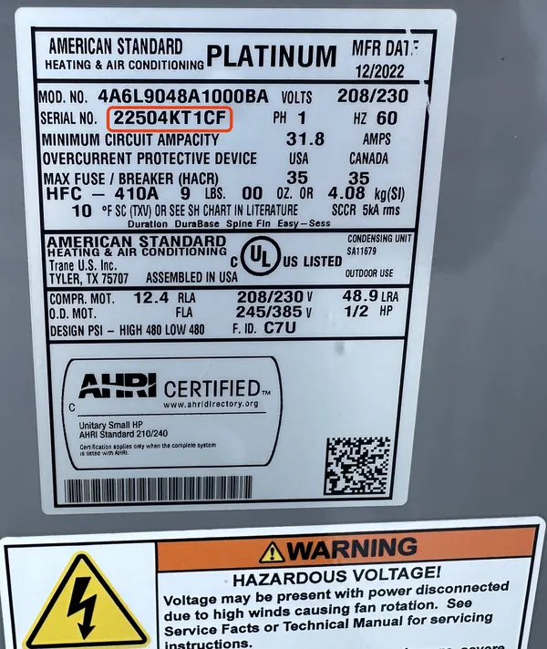 Data plate on an American Standard heat pump, serial number 22504KT1CF outlined in red