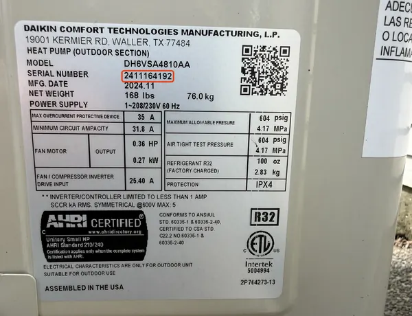 Data plate on a Daikin heat pump, serial number 2411164192 outlined in red