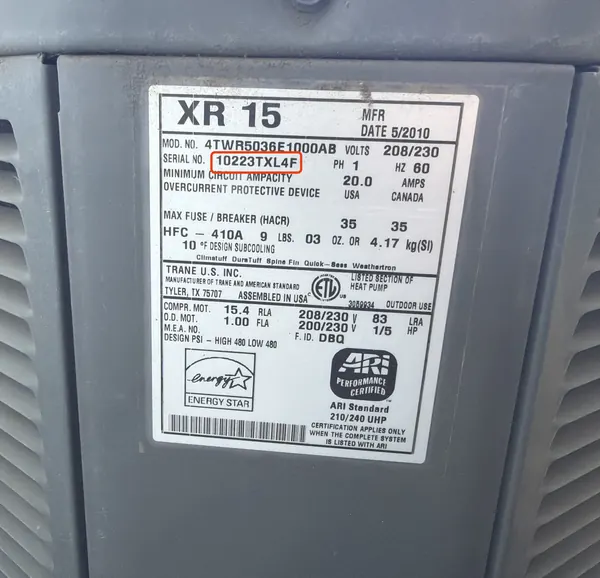 Data plate on the side of a Trane outdoor heat pump, serial number outlined in red
