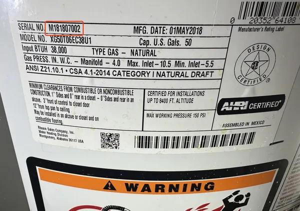 Rating plate on a Rheem gas water heater, serial number M181807002 outlined in red