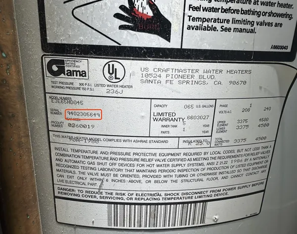 Rating plate on a U.S. Craftmaster electric water heater, serial number 9402305649 outlined in red